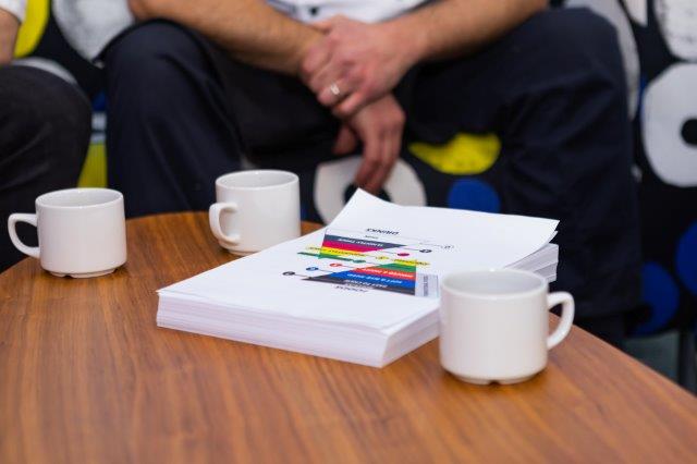 Closeup of cups and a brochure on a coffee table