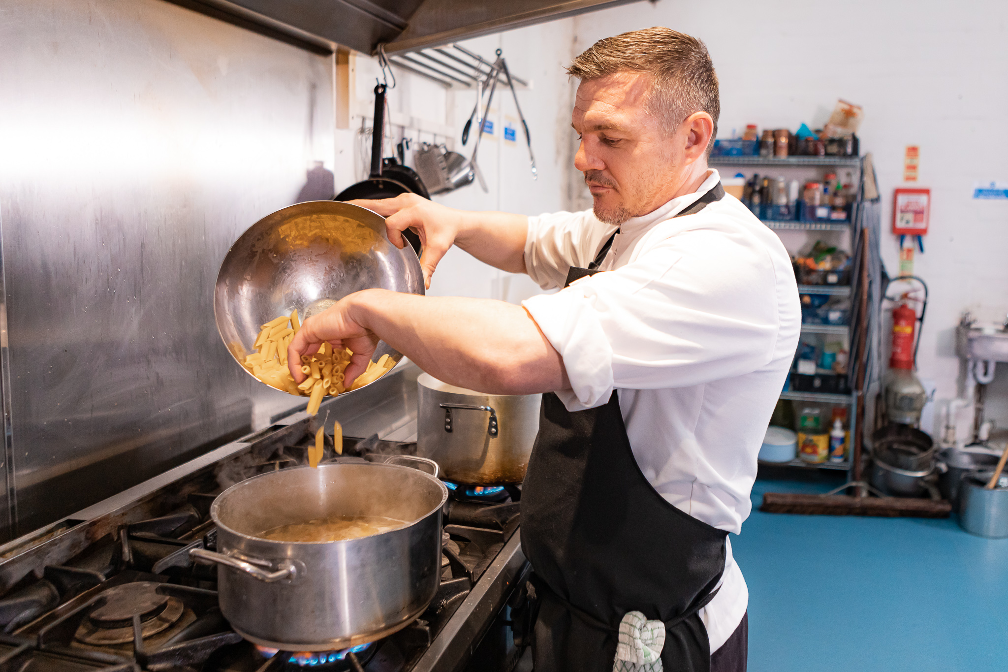 A chef frying food in a wok
